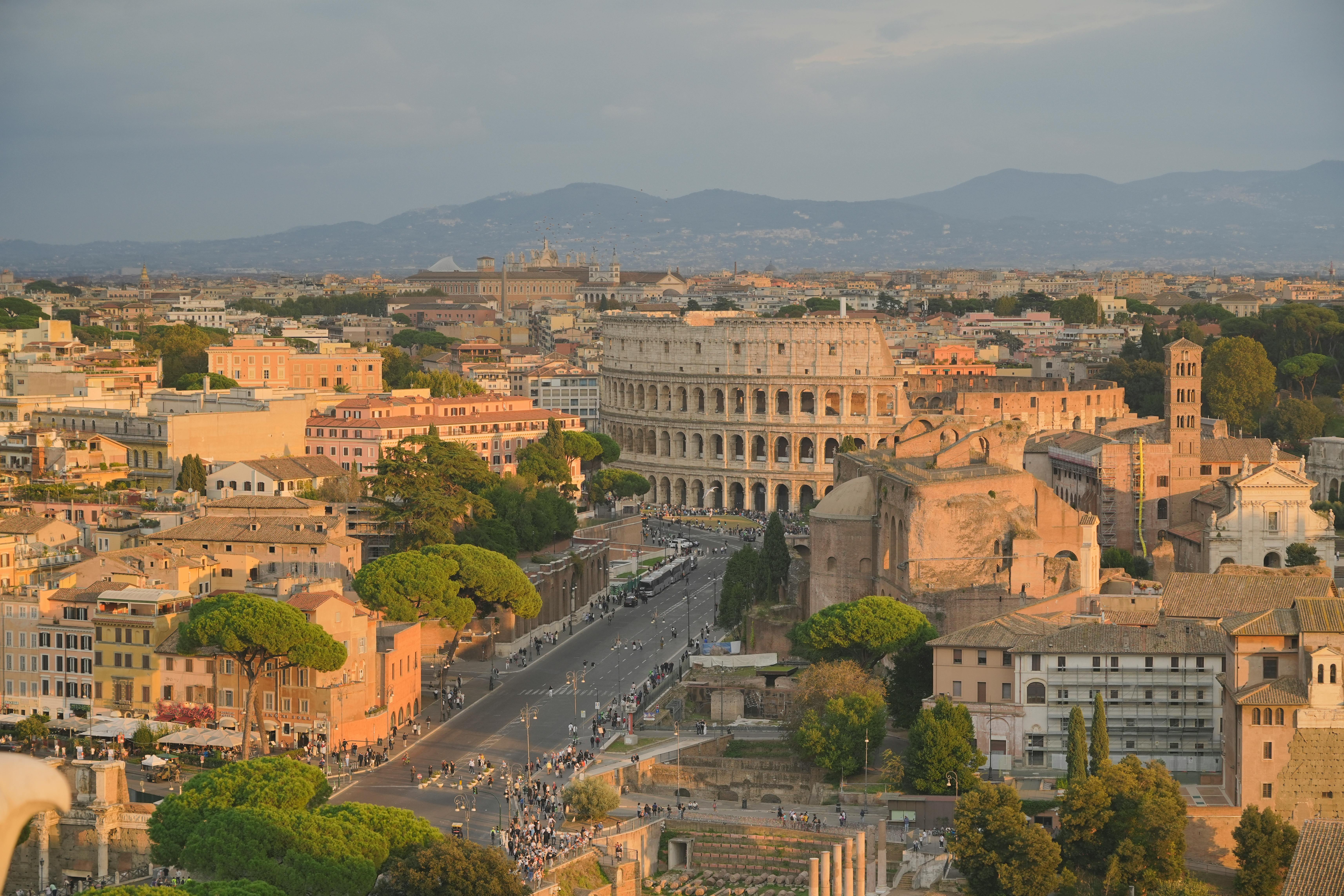 Ücretsiz Gün batımı ışıklarıyla yıkanan ikonik Kolezyum'u da içeren, Roma'nın nefes kesen bir hava görüntüsü. Stok Fotoğraflar