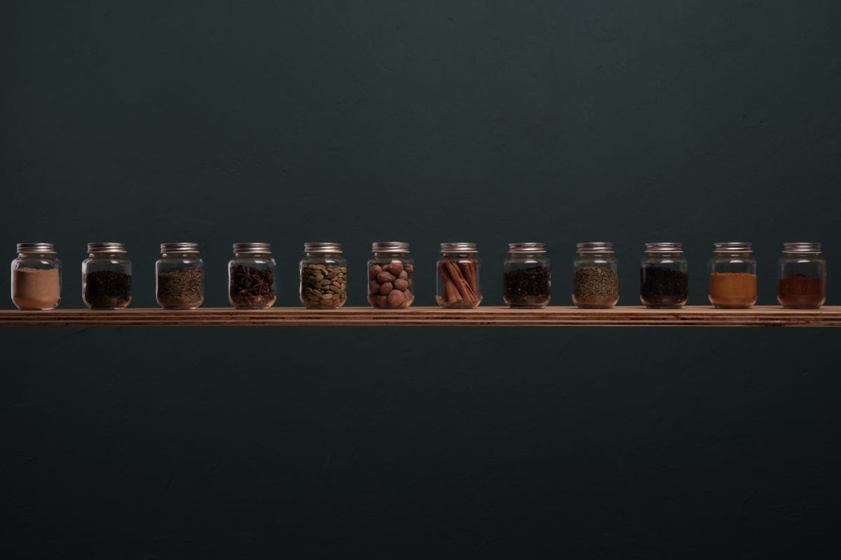 Spice jars lined up in a neat row on a shelf