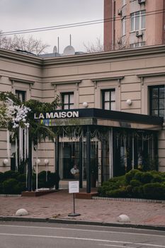 Elegant facade of La Maison restaurant in Kyiv with decorative plants and signage.