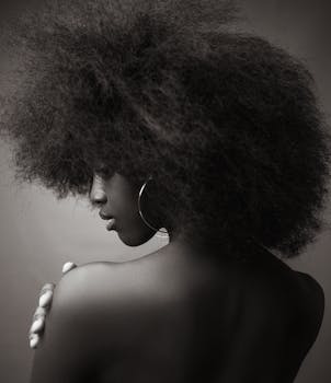 Black and white portrait of a woman with afro hairstyle, turning away.
