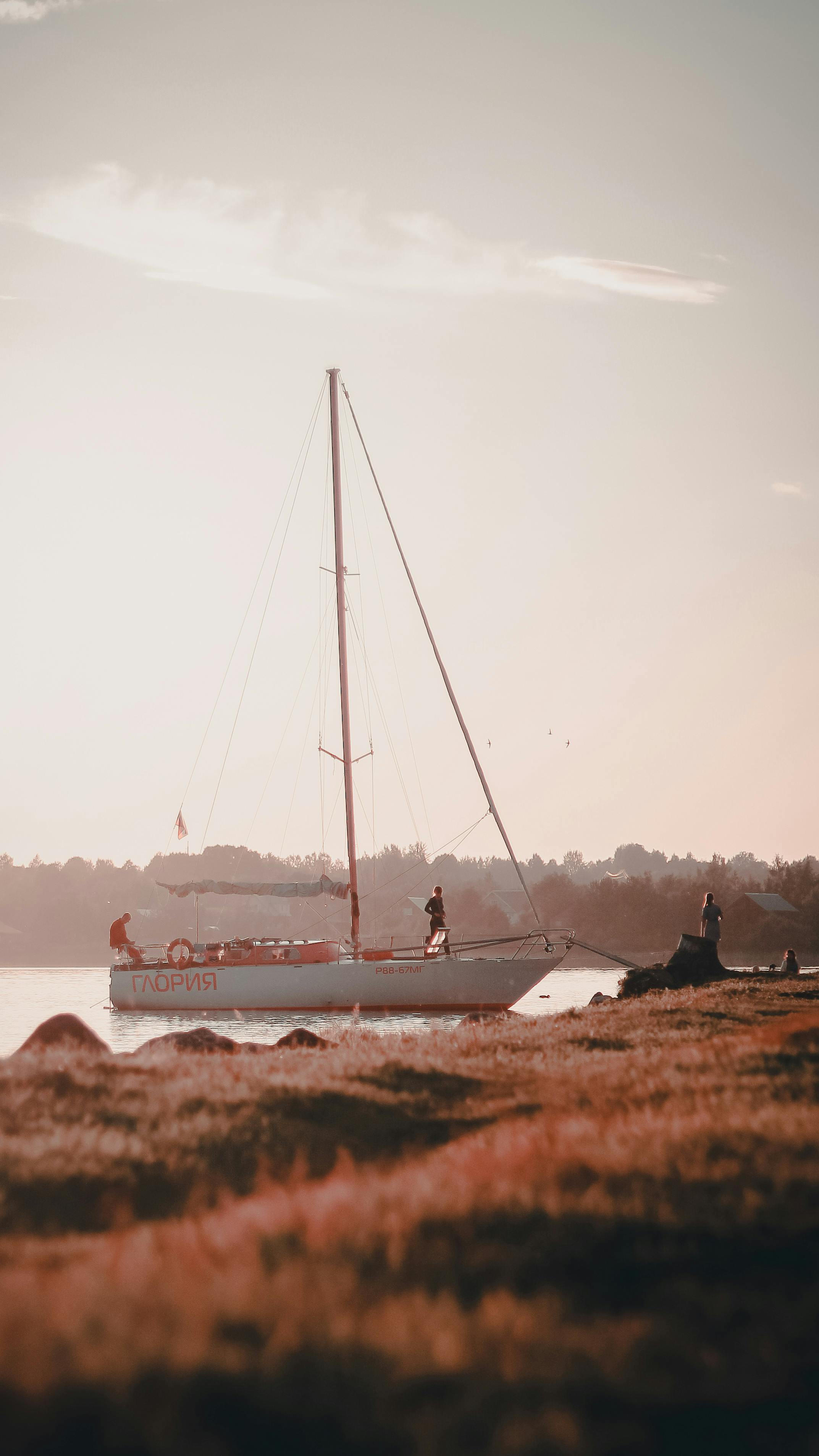 A sailboat docked on tranquil waters during twilight, creating a serene scene perfect for relaxation and escape.