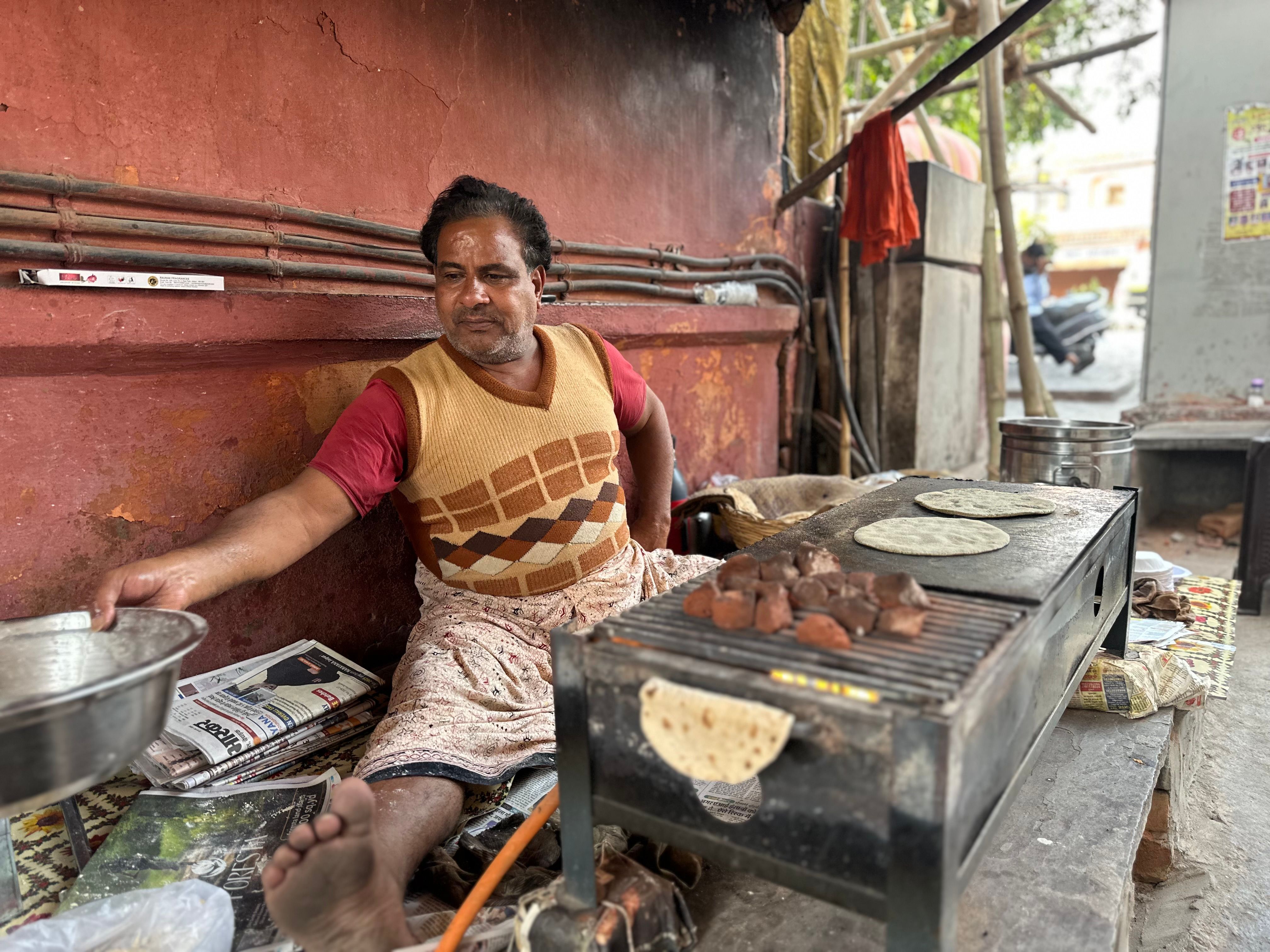 Street vendor preparing flatbreads on an outdoor grill, showcasing local culinary tradition.