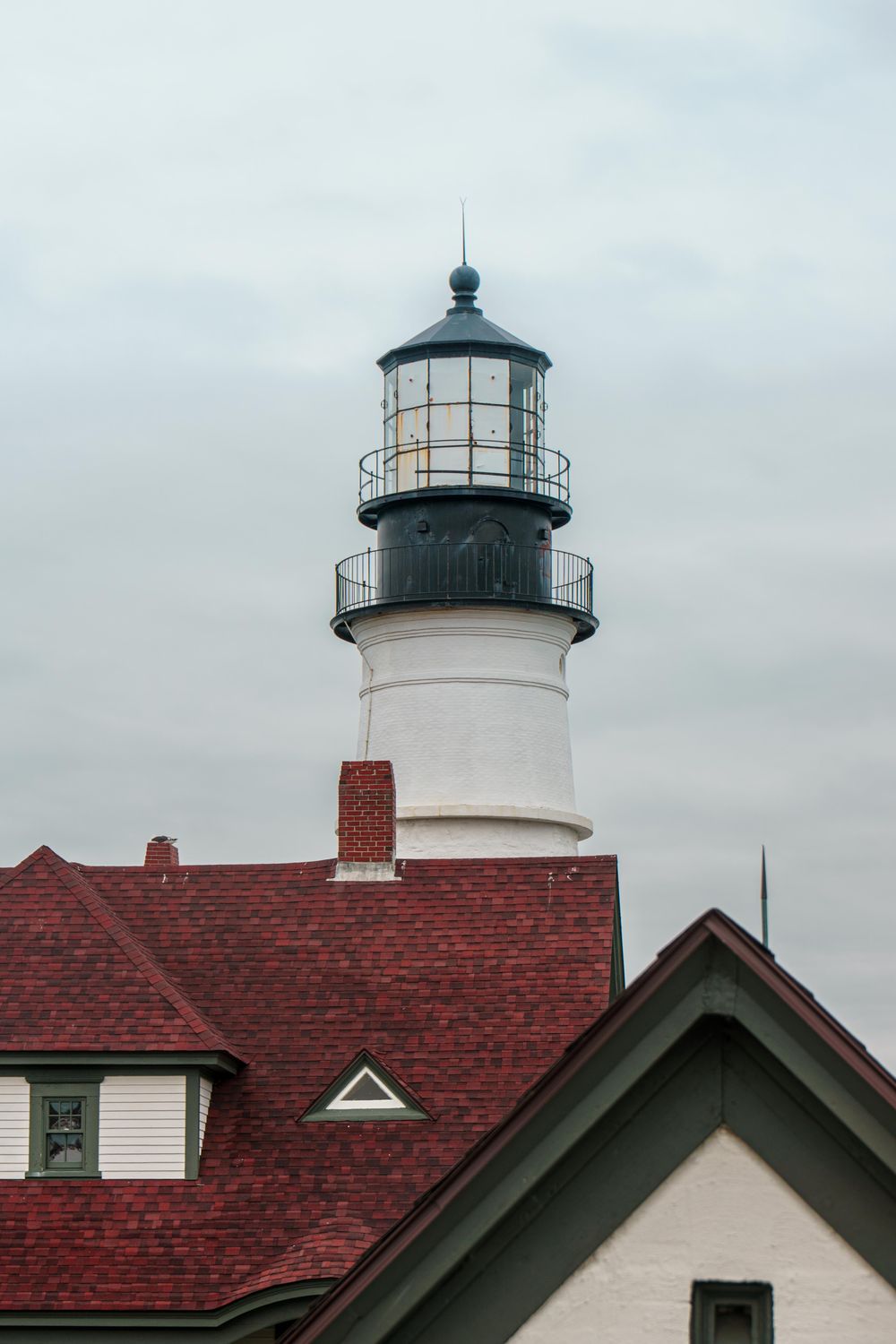Historic Lighthouse with Red Roof on Overcast Day · Free Stock Photo