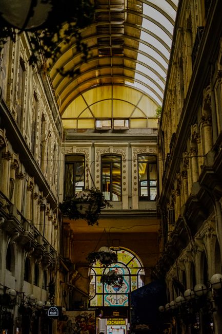 15 Tác Dụng Của Hạt Macca Mọi Người Cần Biết Để Bảo Vệ Sức Khỏe 4 Charming indoor arcade with ornate architecture and a glass roof ceiling, creating a vintage ambiance.
