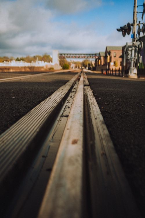 Free Dramatic perspective of railway tracks leading through a cityscape, capturing the essence of travel and urban life. Stock Photo