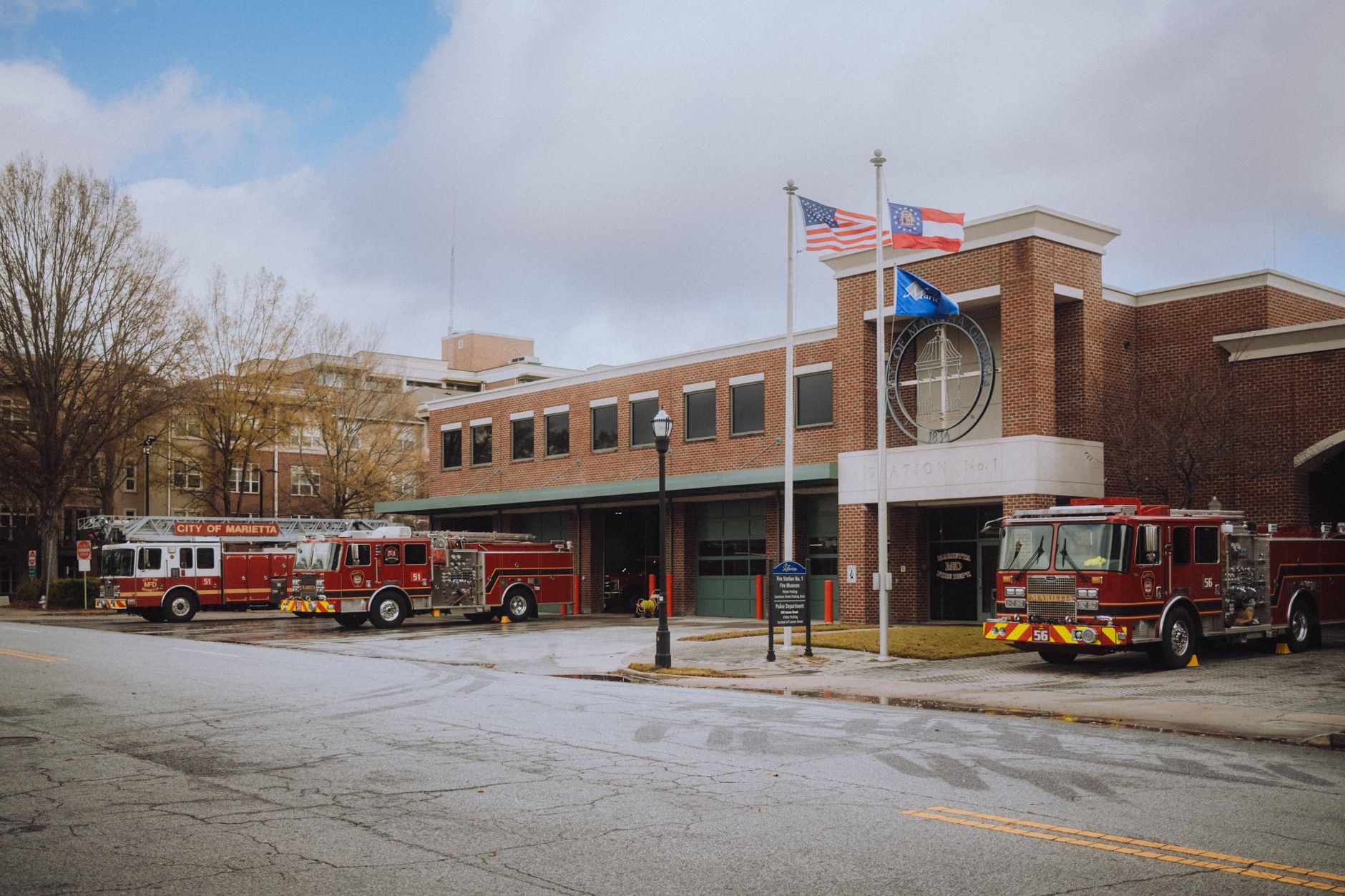Fire trucks parked at the Marietta fire station under a cloudy sky, showcasing emergency services.