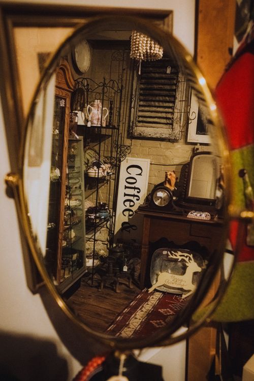 Free Charming vintage decor captured in an oval mirror reflection, highlighting a cozy cafe setting. Stock Photo