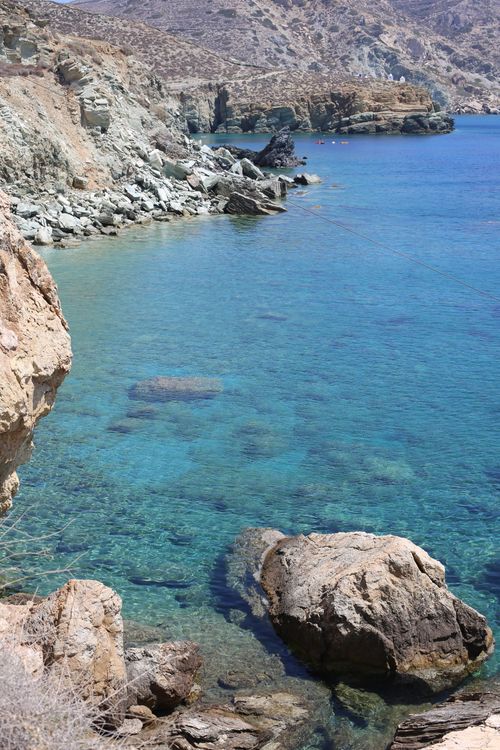 Free Sunny rocky coastline view with clear blue water and rugged cliffs, perfect for travel inspiration. Stock Photo