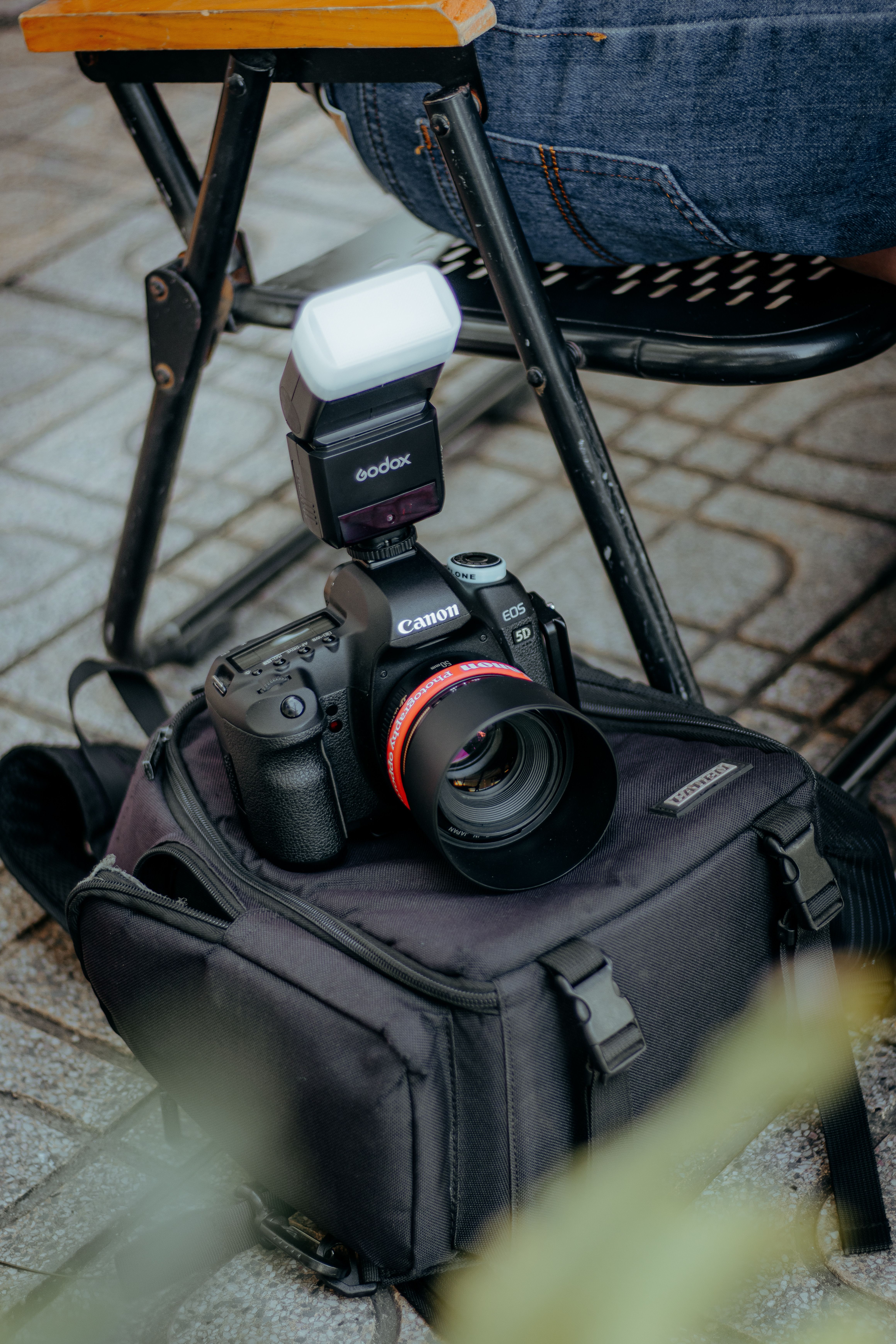 Professional Camera on Bag Outdoors with Flash · Free Stock Photo