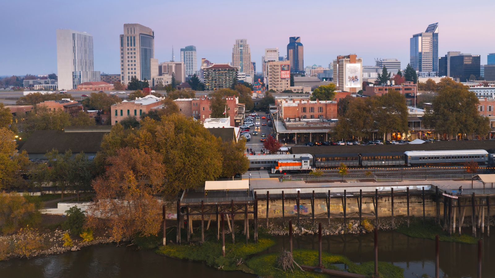 A beautiful twilight aerial view of Sacramento's urban skyline with historic Old Sacramento in foreground.