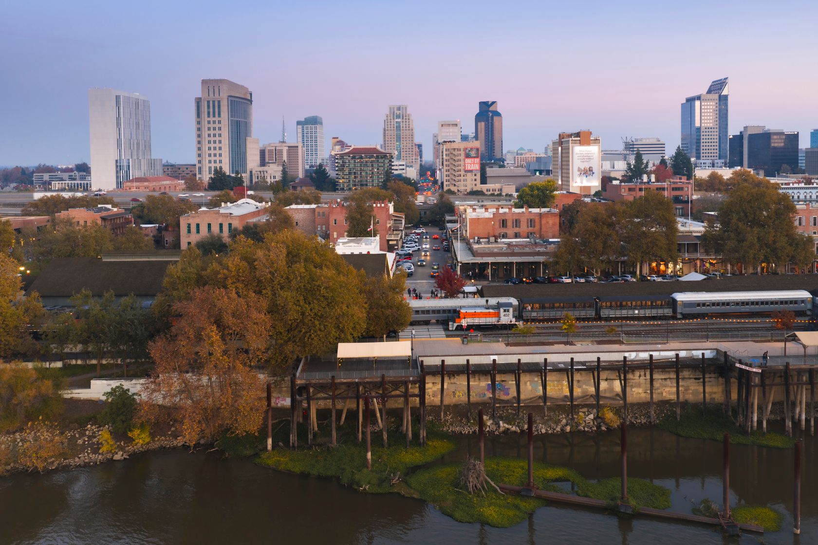 A beautiful twilight aerial view of Sacramento's urban skyline with historic Old Sacramento in foreground.