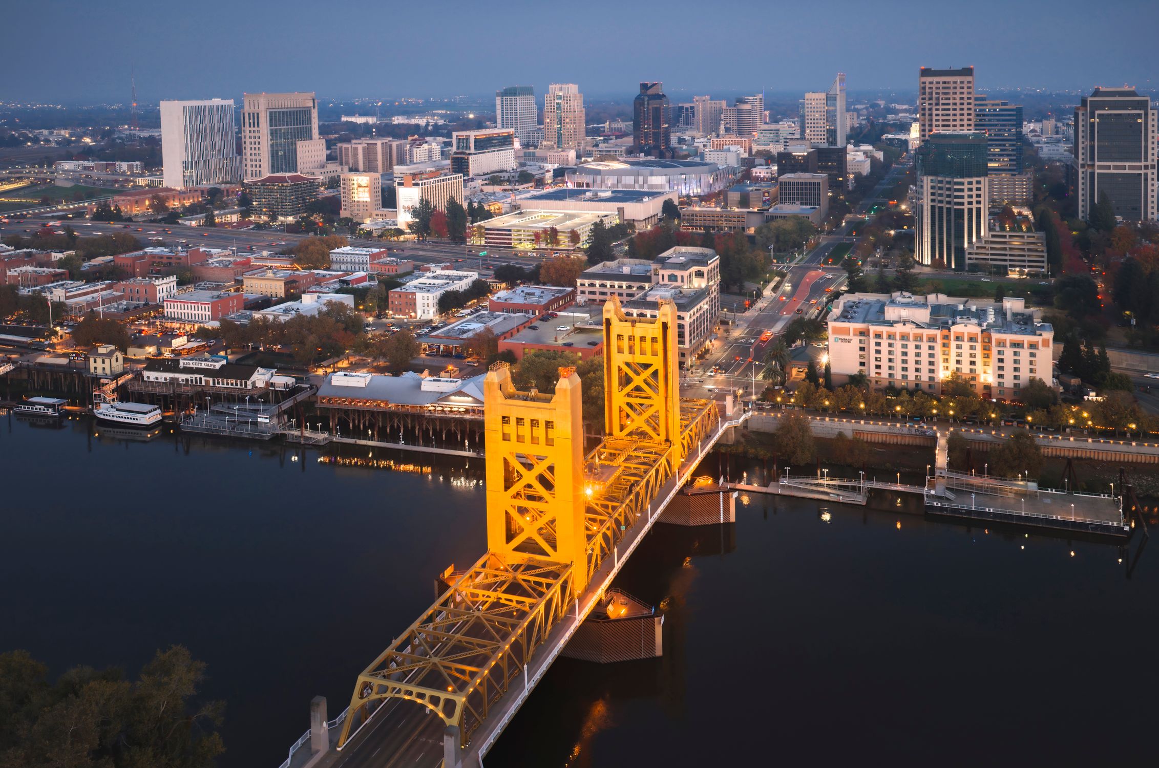 Aerial view of the illuminated Tower Bridge in Sacramento overlooking the cityscape at dusk.