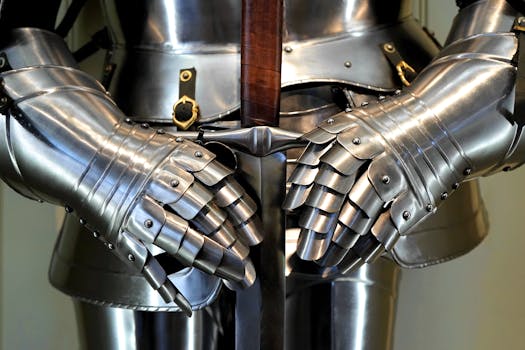 Detailed view of medieval armor gauntlets holding a sword.