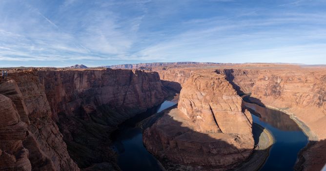 Panoramic view of Horseshoe Bend showcasing dramatic sandstone cliffs and river curves in Arizona, USA.