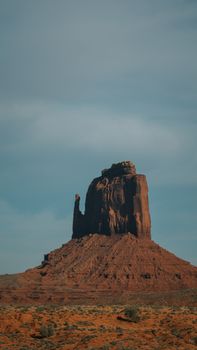 Stunning view of a towering butte in Monument Valley, Arizona, under a clear sky.