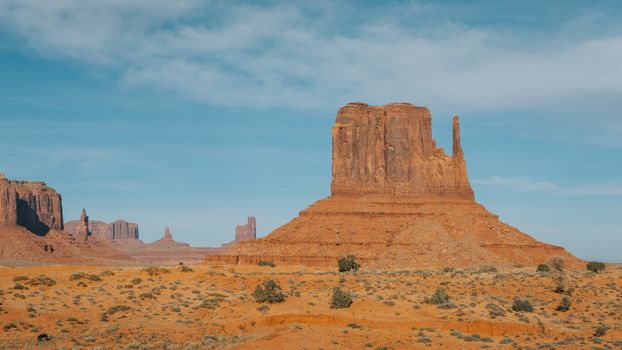 Stunning view of a butte in Monument Valley, Arizona under a bright blue sky.