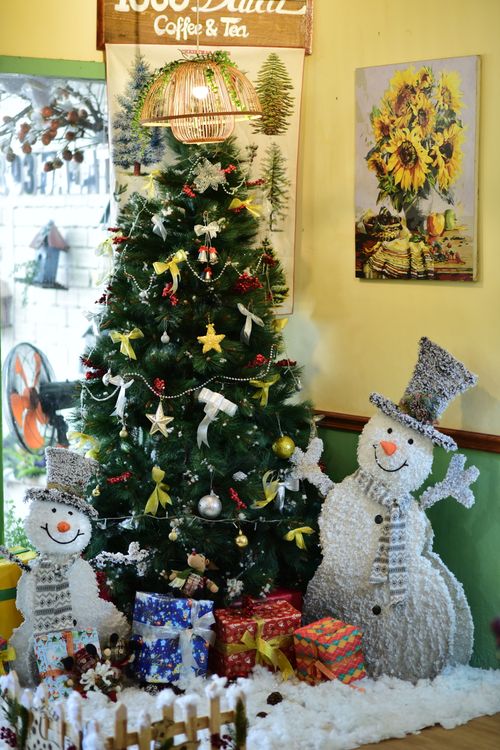 Free Cozy indoor scene with decorated Christmas tree and cheerful snowman figures. Stock Photo