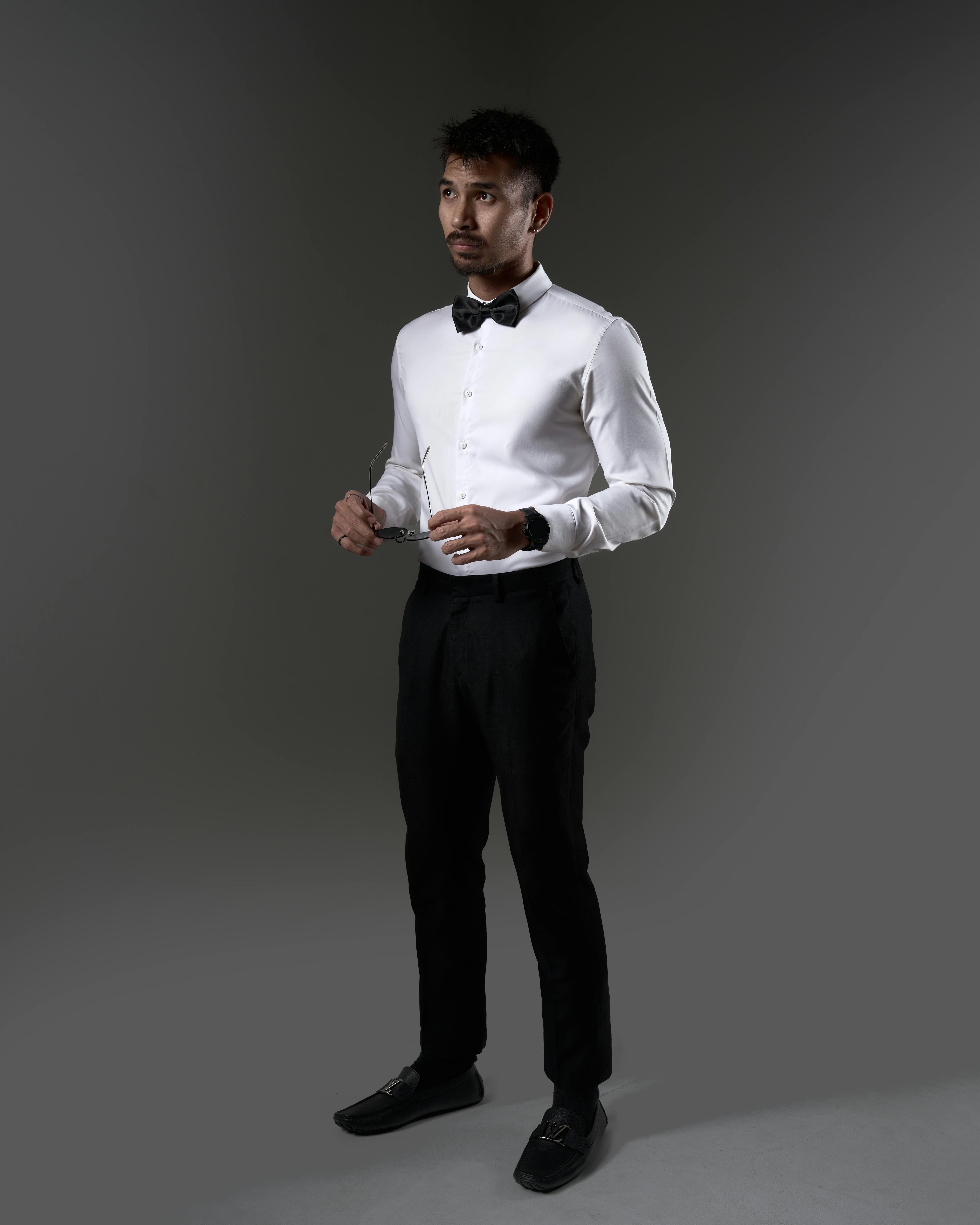 Gratis Ritratto di un uomo elegante con camicia bianca e papillon, studio di Phnom Penh. Foto a disposizione