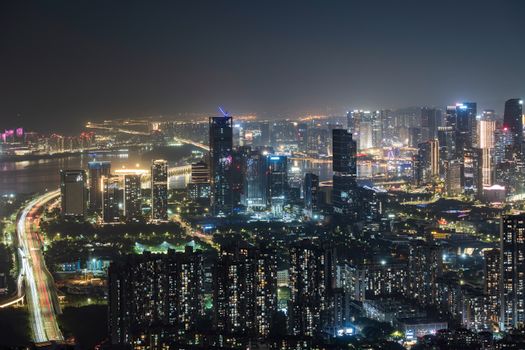 Stunning urban skyline at night with illuminated skyscrapers and bustling city lights.