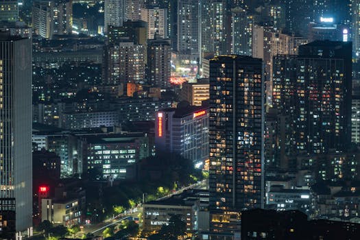 Vibrant city skyline illuminated at night with towering skyscrapers.