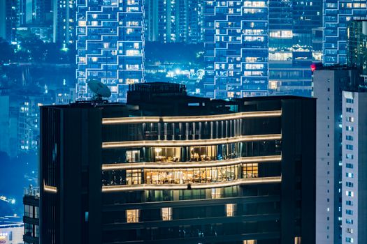 Vibrant nighttime cityscape showcasing modern high-rise architecture with glowing windows.