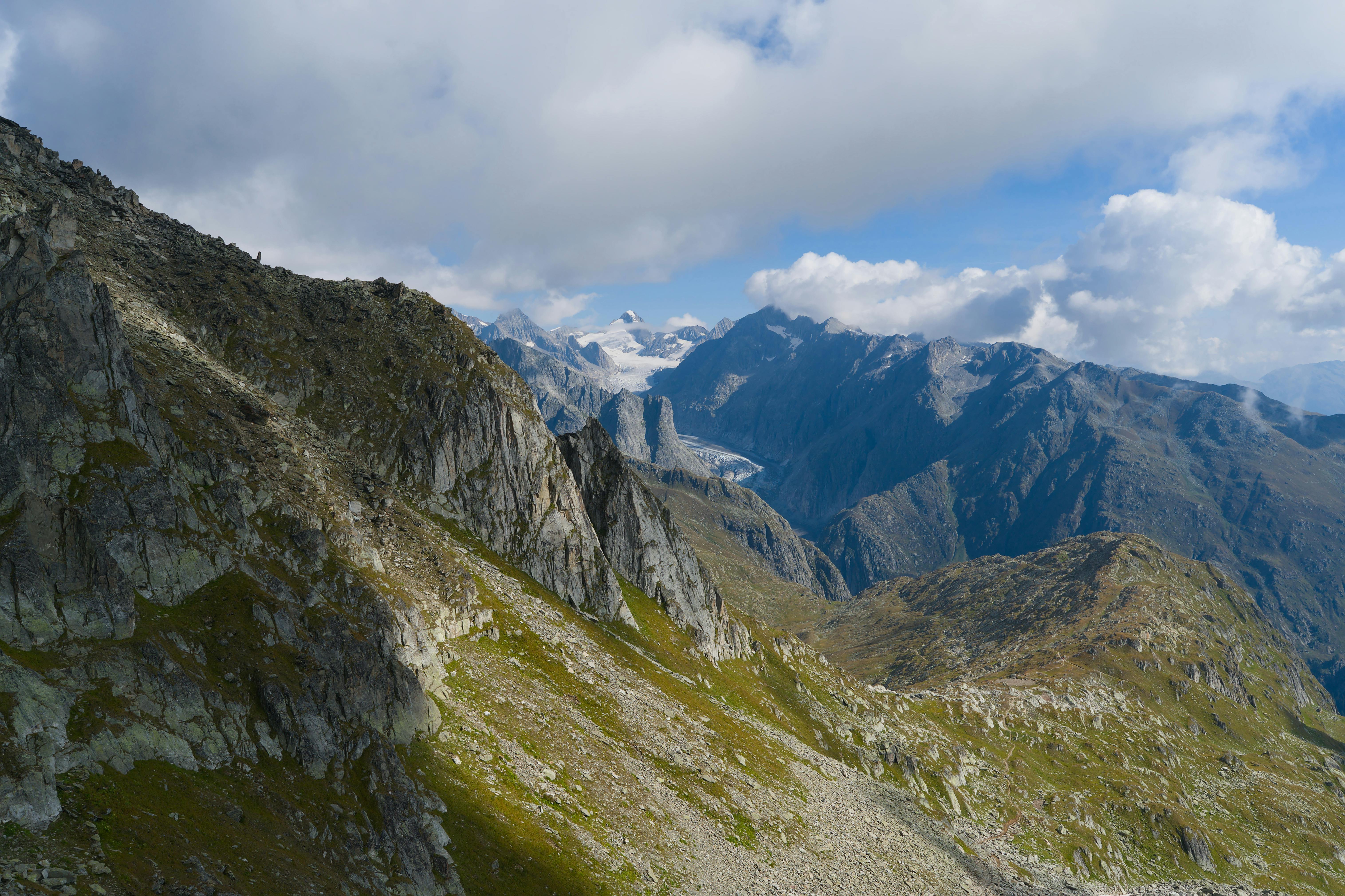 Breathtaking view of Swiss Alps with dramatic peaks and lush valleys under a blue sky. - Aletsch Arena