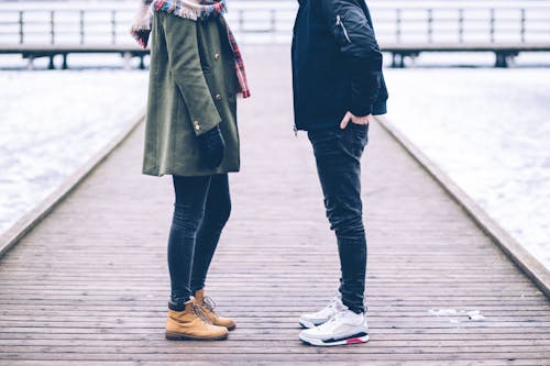 Woman and Man Standing on Brown Wooden Dock