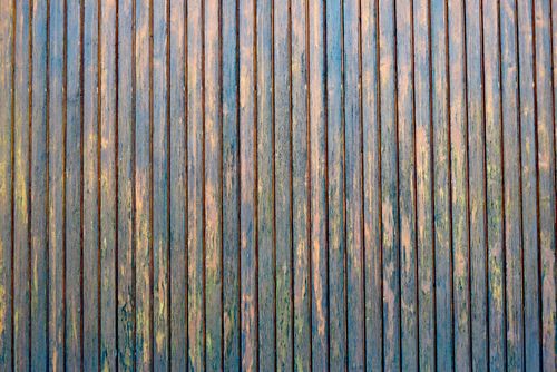 Free Detailed texture of an aged wooden wall with peeling blue and brown paint. Stock Photo