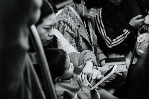 Free A candid black and white photo capturing a family scene in a Nanjing subway. Stock Photo