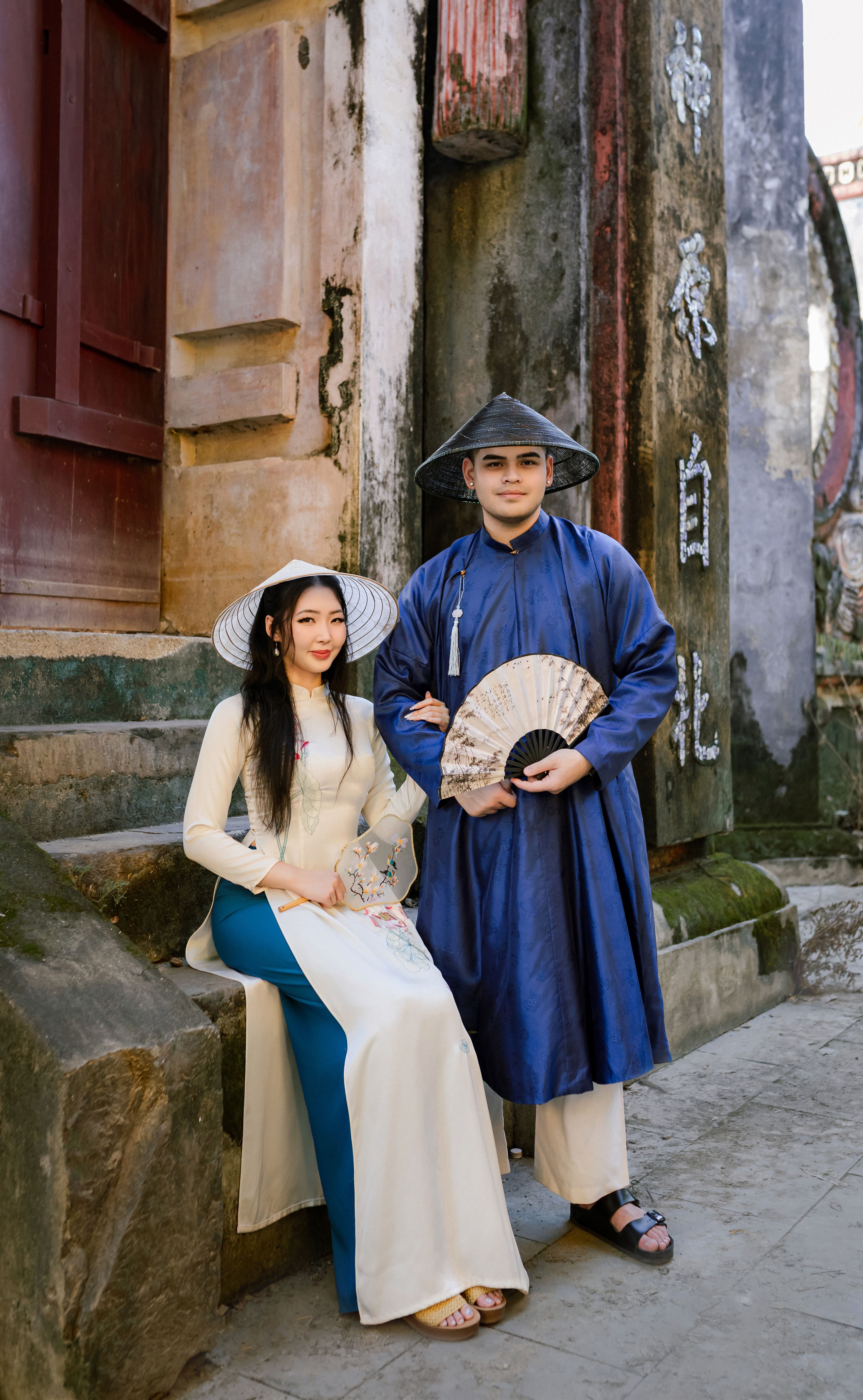 Couple in traditional Vietnamese clothing in Hội An's historic setting, showcasing cultural heritage.
