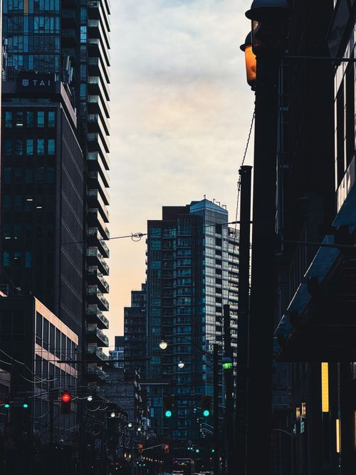 Free Evening view of city street with skyscrapers and streetlights at twilight. Stock Photo