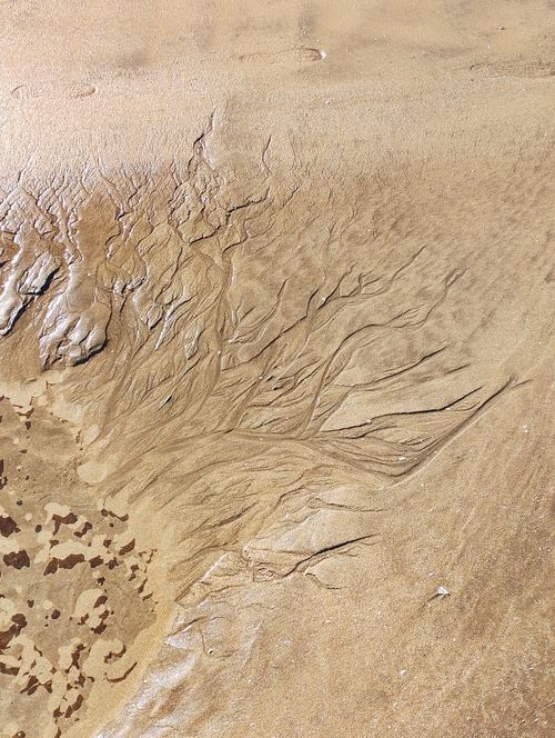 Free Close-up view of intricate sand patterns created by water at low tide, Casablanca beach, Morocco. Stock Photo