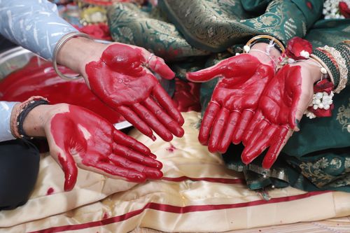 Free Close-up of hands with red paste during a cultural ceremony in India. Stock Photo