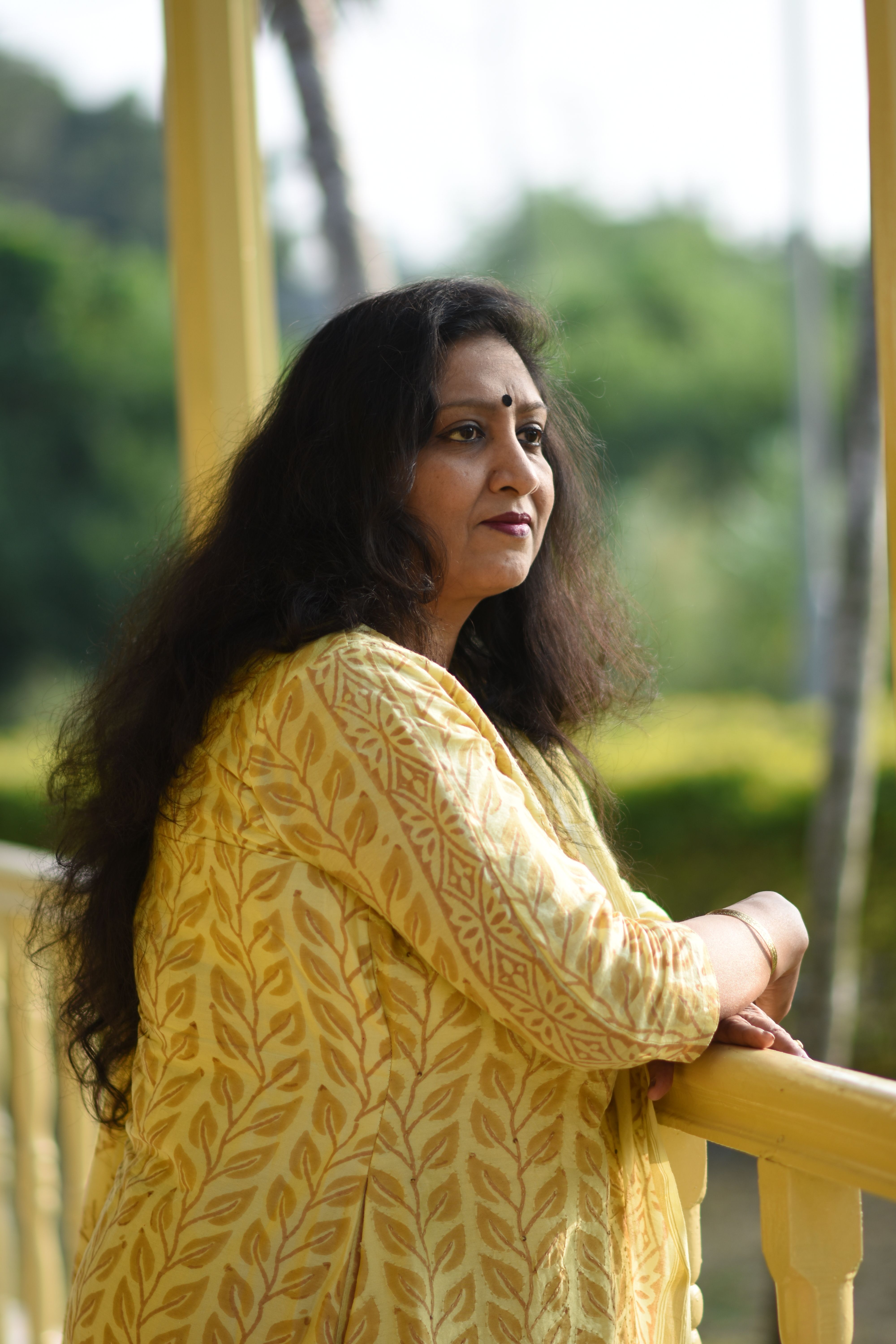 Serene outdoor portrait of a woman in Rambha, India, with lush greenery.