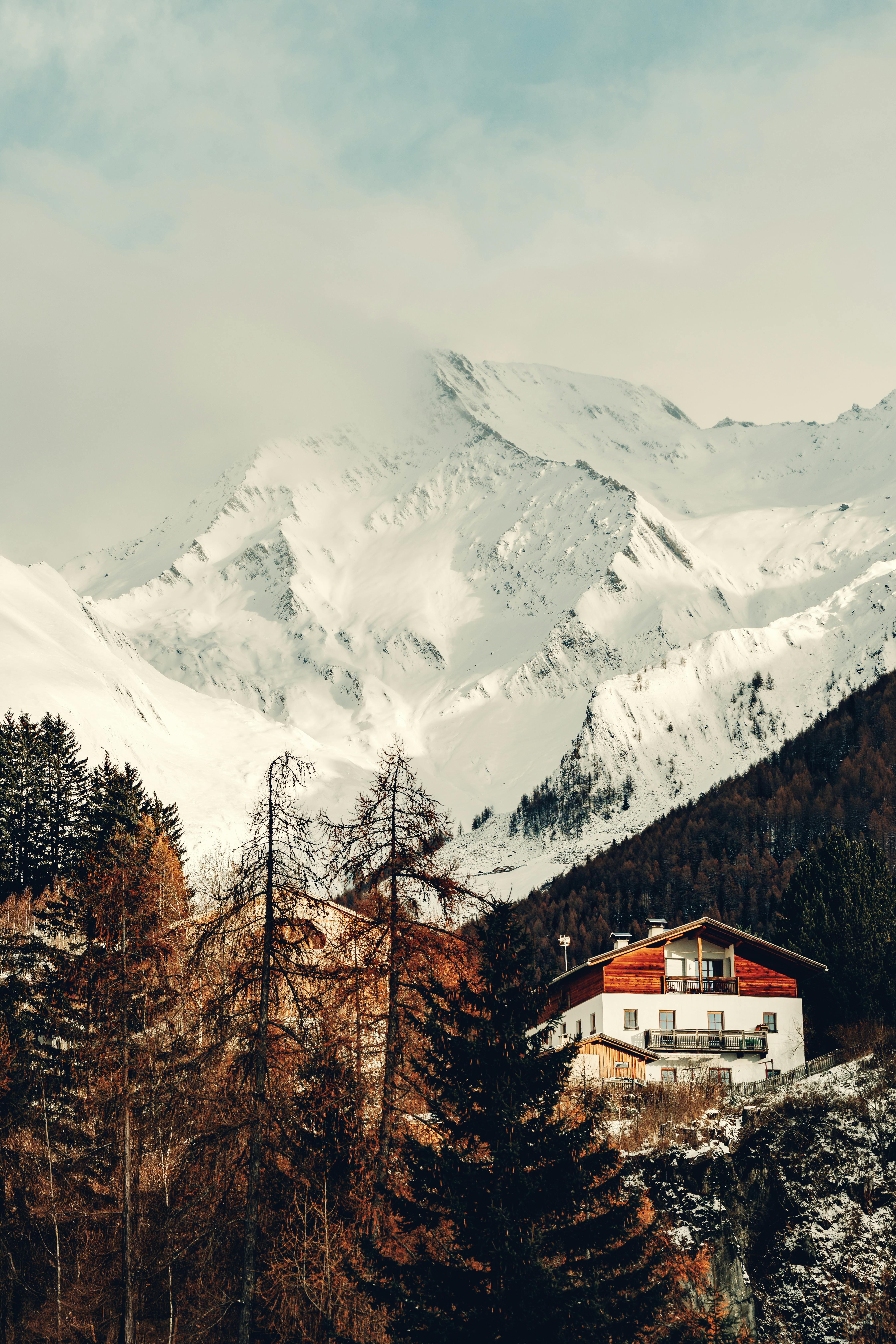 Charming alpine village nestled beneath snow-capped mountains in winter, showcasing serene beauty.