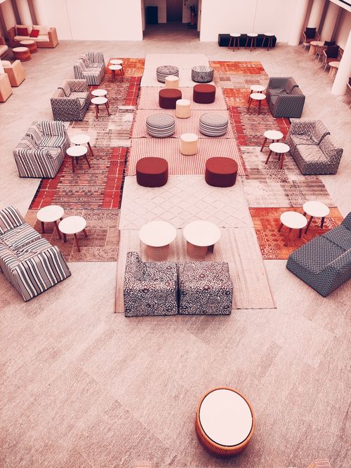 Free Stylish modern lounge setup with geometric patterns and colorful seating. Stock Photo