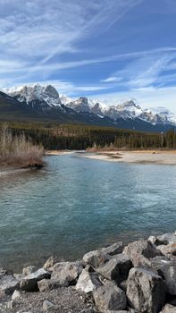 Breathtaking view of the Rocky Mountains with river and sky in clear daylight.