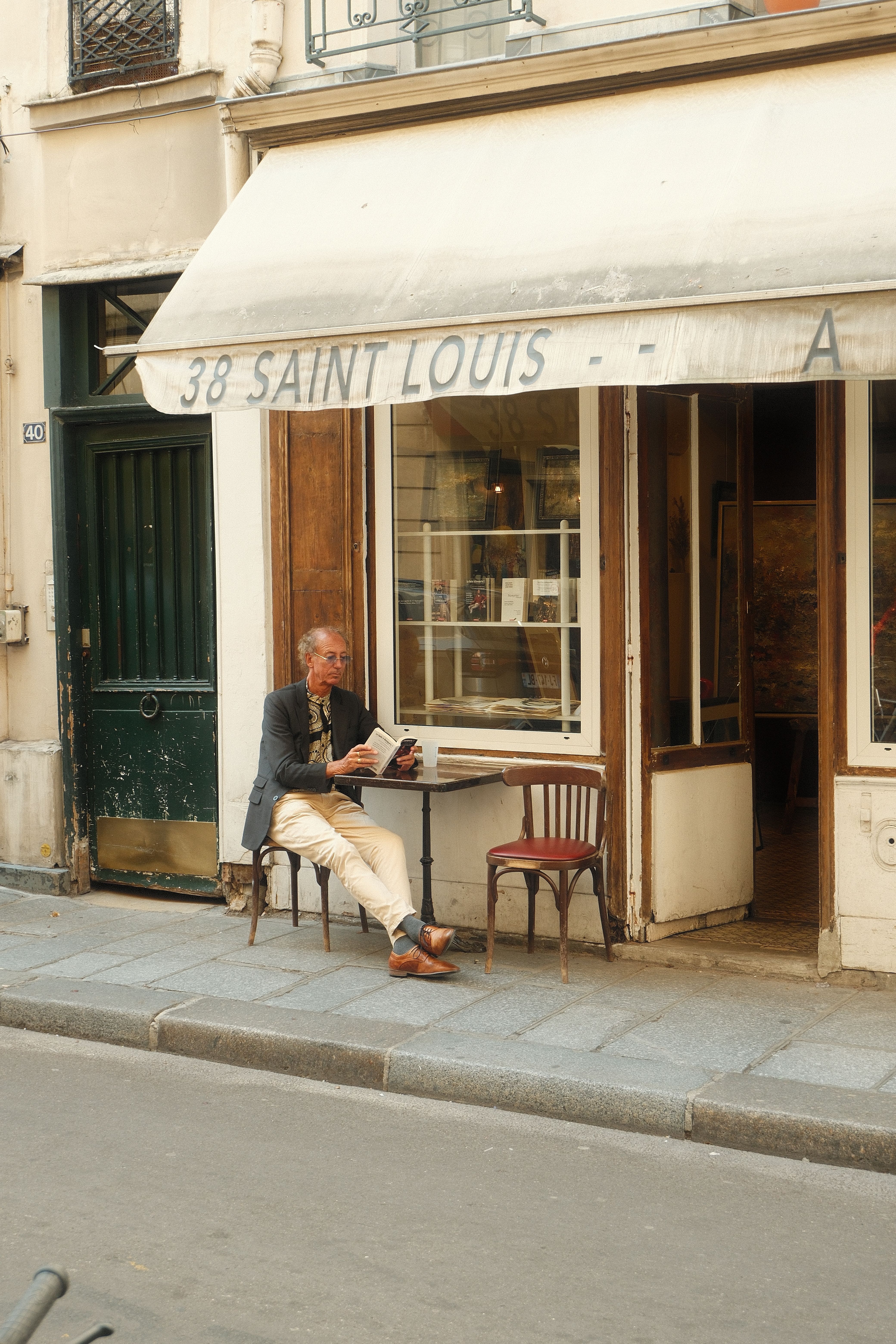 Elderly man sitting at a Paris café, creating a serene street scene.