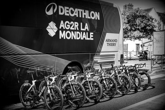 Row of professional racing bicycles lined up in front of team bus, monochrome style. — photo by Jean Marc Bonnel
