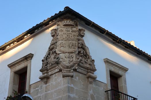 Detailed view of a historic coat of arms on a building in El Puerto de Santa María, Spain.