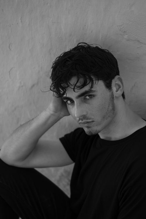 Free Dramatic black and white portrait of a young man with wet hair, exuding an artistic vibe. Stock Photo