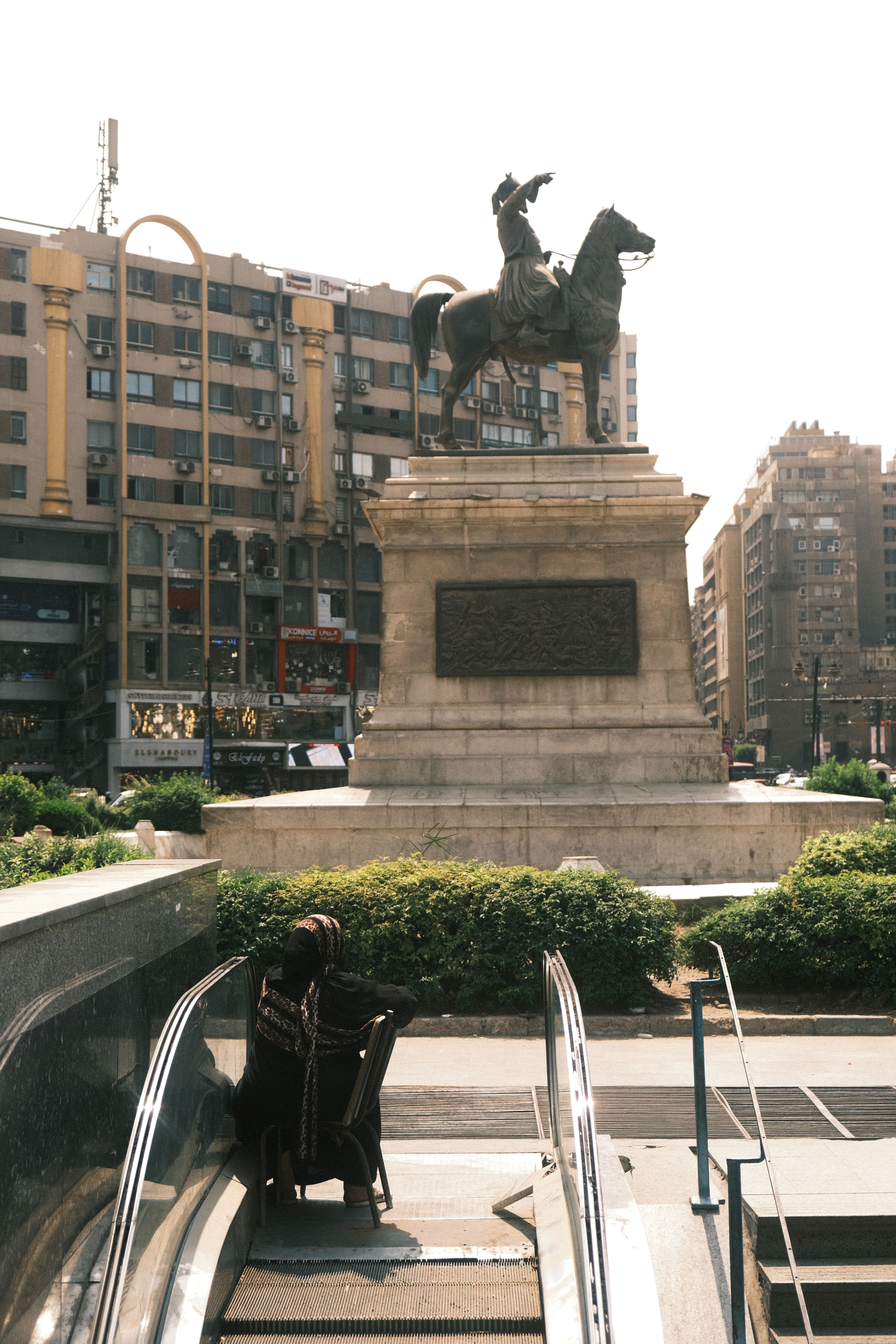 Dynamic street scene in Cairo featuring a statue and urban life.