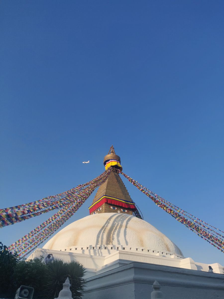 Boudhanath Stupa with colourful prayer flags against a clear blue sky in Kathmandu