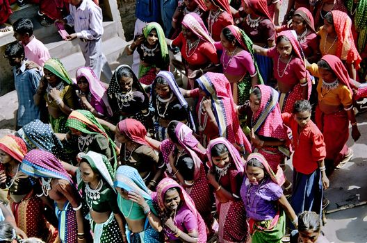 A lively group in colorful traditional attire participating in a cultural parade outdoors.