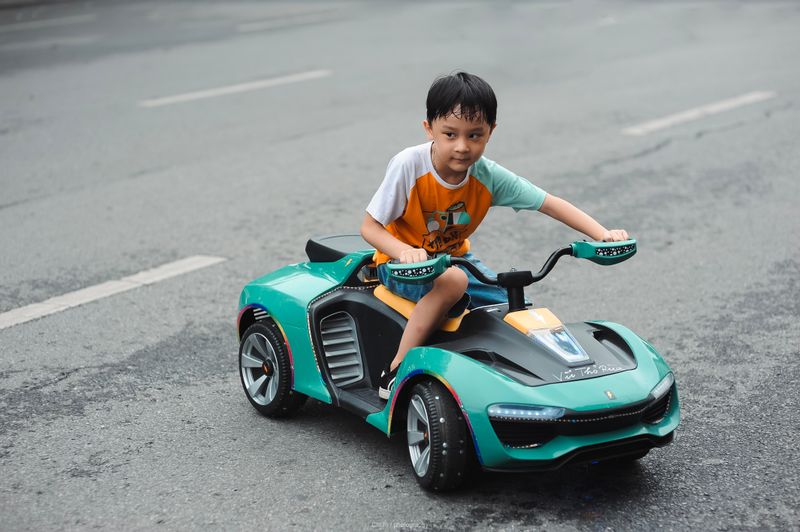 Bé trai lái xe đồ chơi điện ngoài trồi — Ảnh: Thang Nguyen trên Pexels