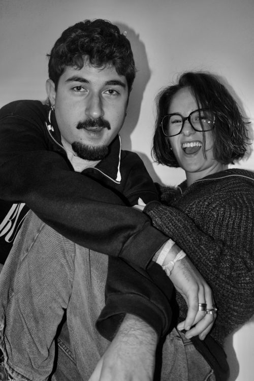 Free Black and white portrait of two friends casually sitting and smiling. Stock Photo