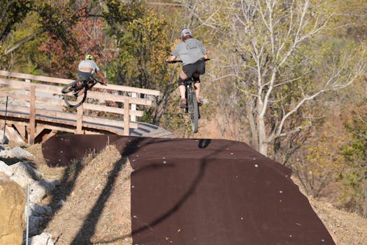 Two cyclists enjoying an exhilarating mountain biking session outdoors in a scenic autumn park.