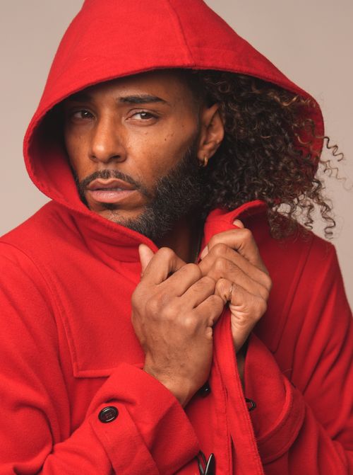 Free Close-up portrait of a man in a red hooded coat exuding confidence and style. Stock Photo