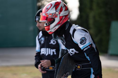 Free Two go-kart racers in helmets and racing gear prepare for an outdoor race, exuding focus and determination. Stock Photo