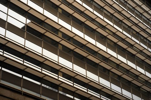 Free Close-up of a modern building facade with glass and steel grid pattern. Stock Photo